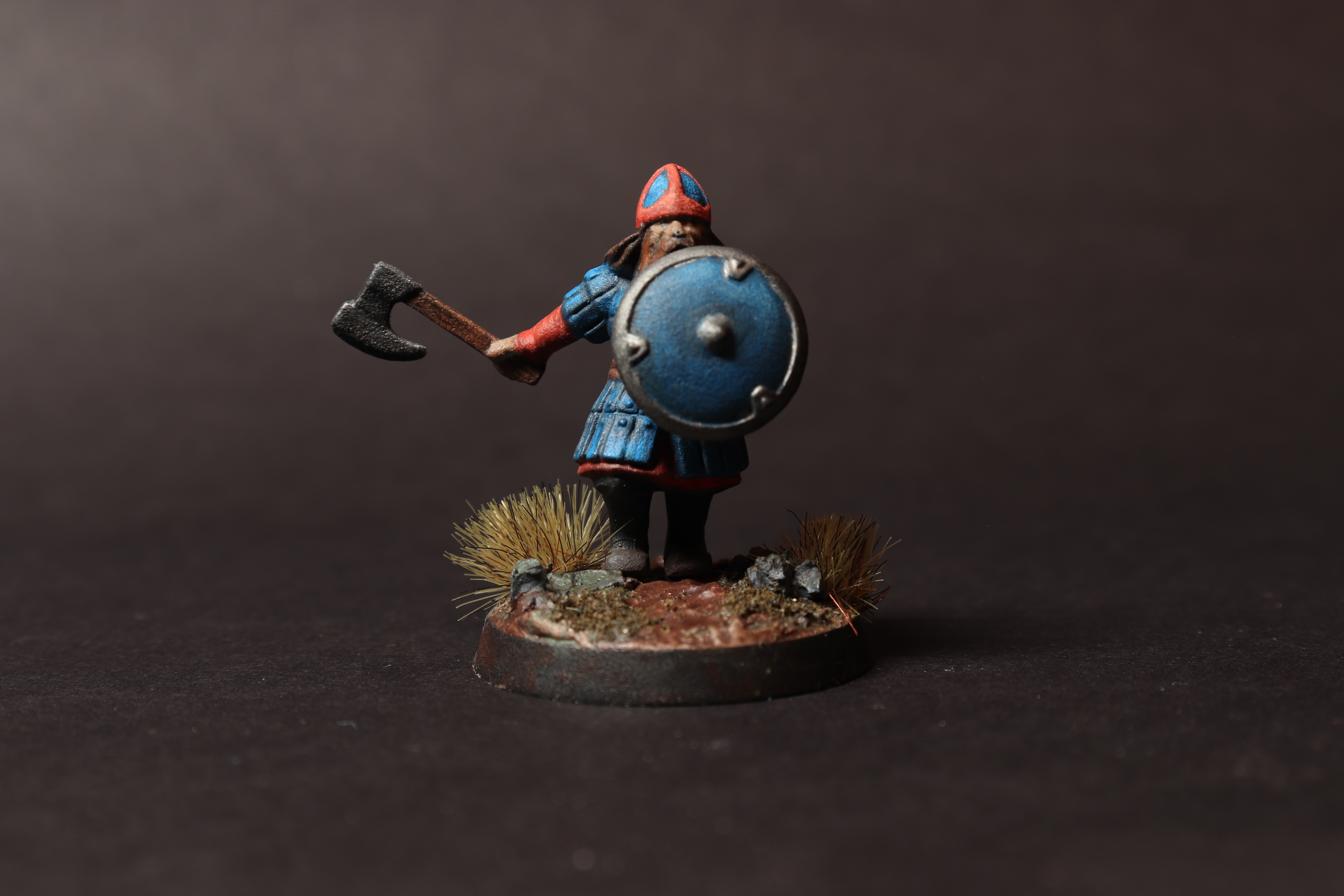 Painted Middle Earth Strategy Battle Game dwarf warrior miniature shown from the front with a blue shield, axe, and textured base.